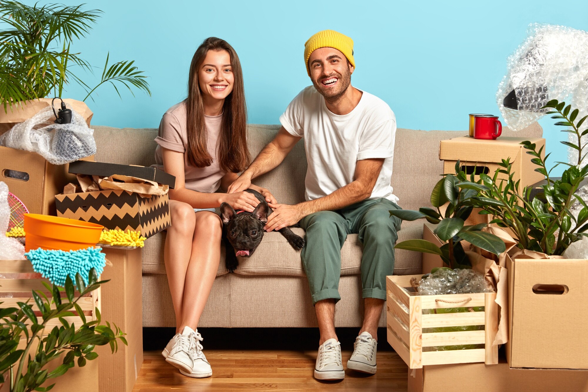 Avoid Capital Gains Tax on Inherited Property happy young couple sitting on the couch surrounded by boxes