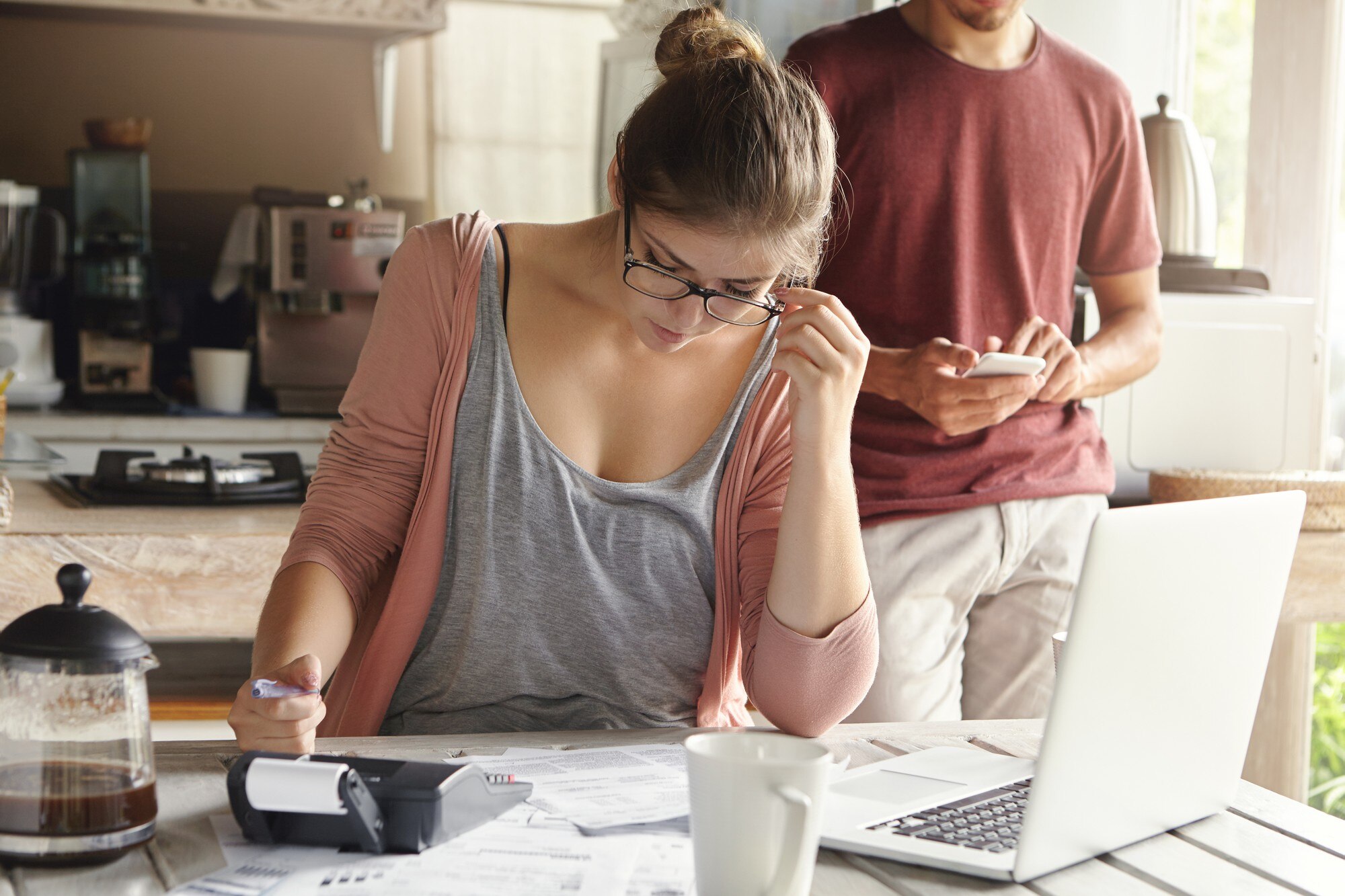 How to Sell Your House in 5 Days serious young woman with hair bun wearing glasses looking through finances