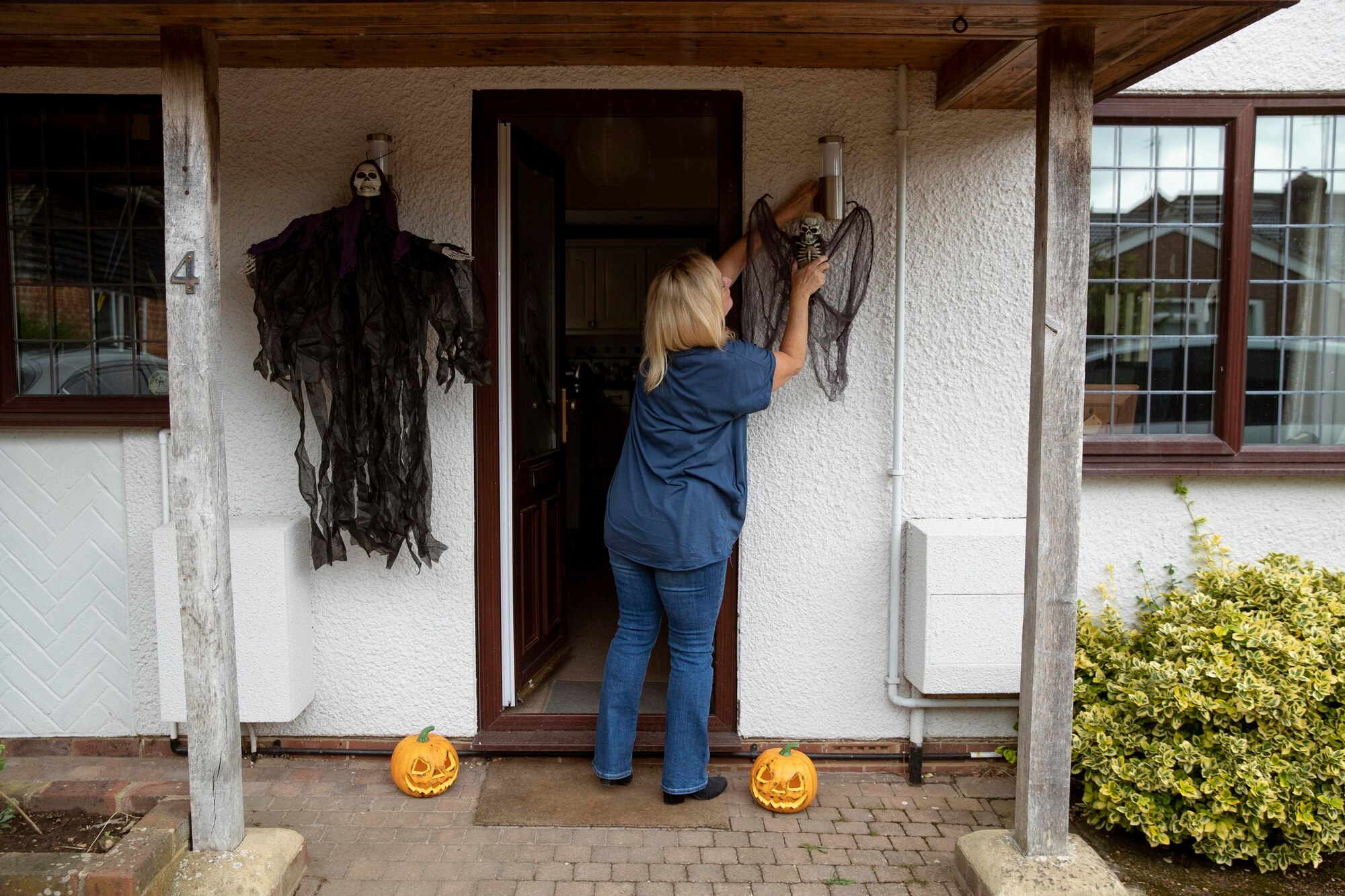 How To Sell A House With Fire Damage woman decorating her home for halloween